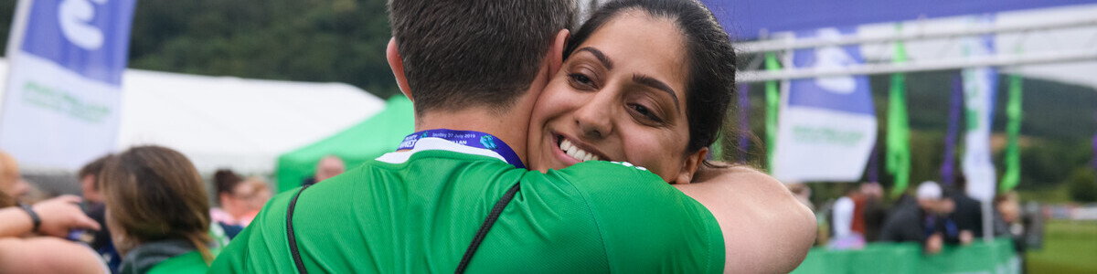 A woman hugging a man at an outdoor fundraising event.