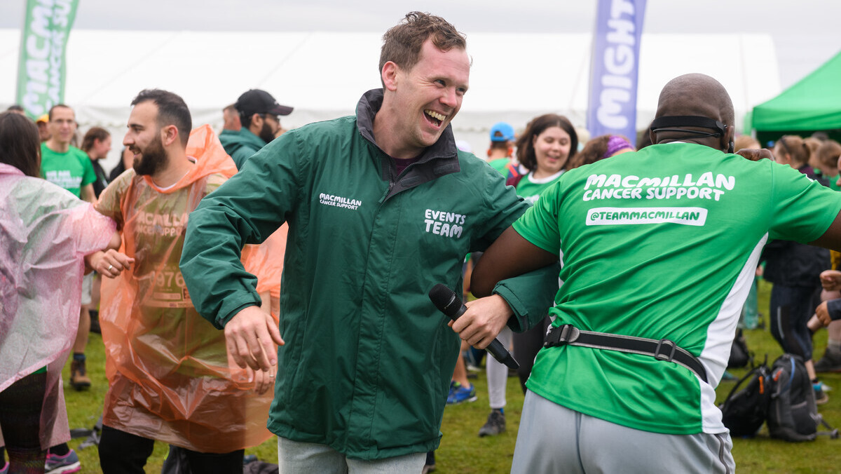 Two people dancing at the finish line of a Macmillan Mighty Hike event.
