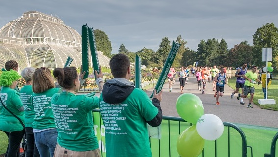 Macmillan supporters in front of Kew Gardens' Palm House cheering on runners.