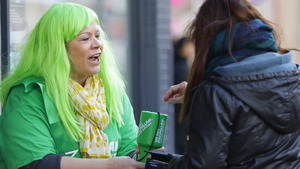 A woman with green hair collecting money for Macmillan on the street