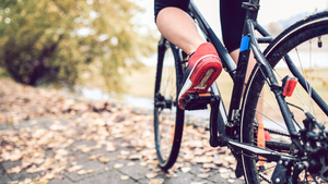 Close up shot from behind of a woman riding a bike along a path by a canal.