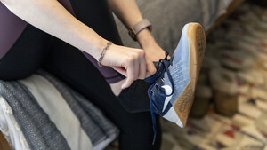 A woman putting on running shoes 