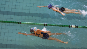 Aerial photo of two women swimming lengths of a swimming pool