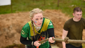 A woman pulling herself up a rope