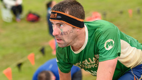 A man looking focussed taking part in an obstacle race