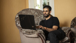 Amuz using his laptop while sitting in his living room