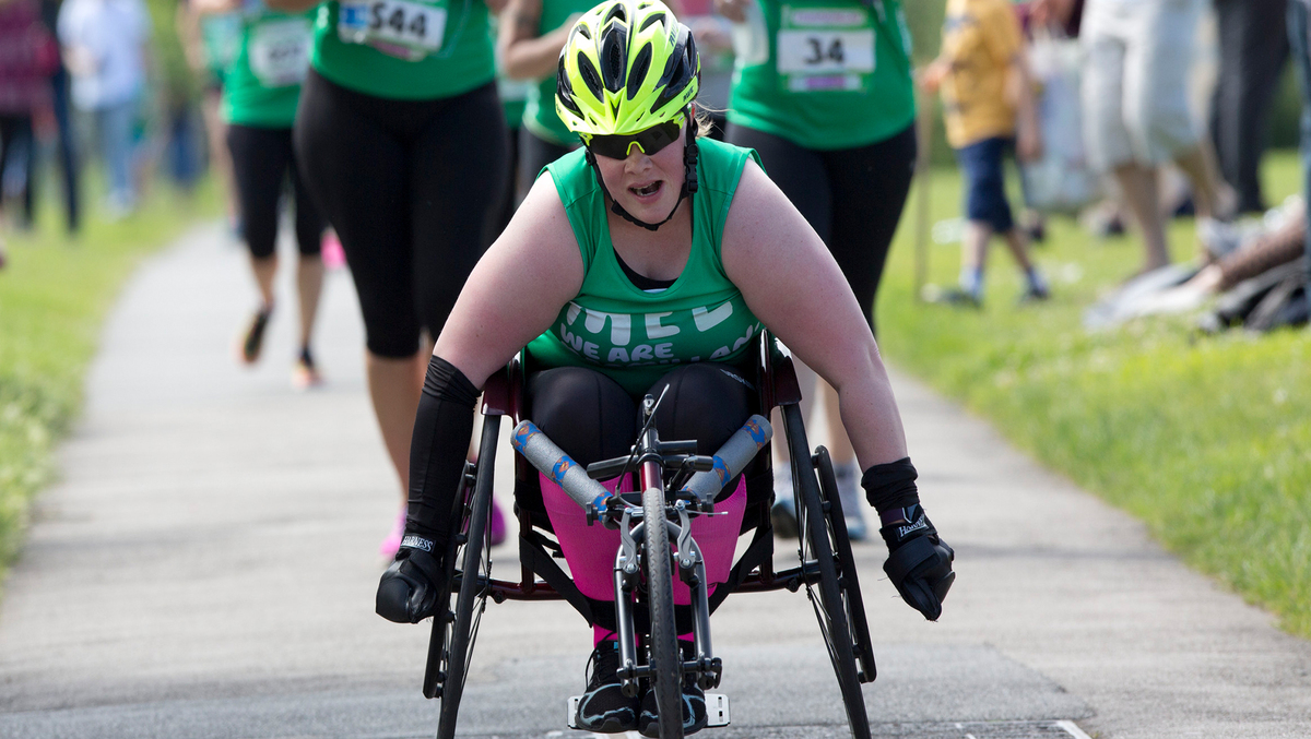A woman in a racing wheelchair taking part in a Macmillan event