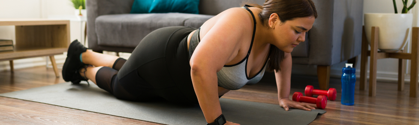 A woman doing a push up in her living room