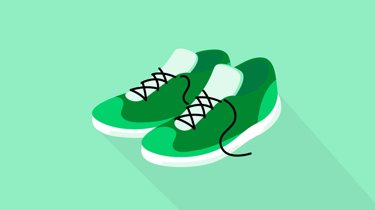 Dark green training shoes on a light green background.