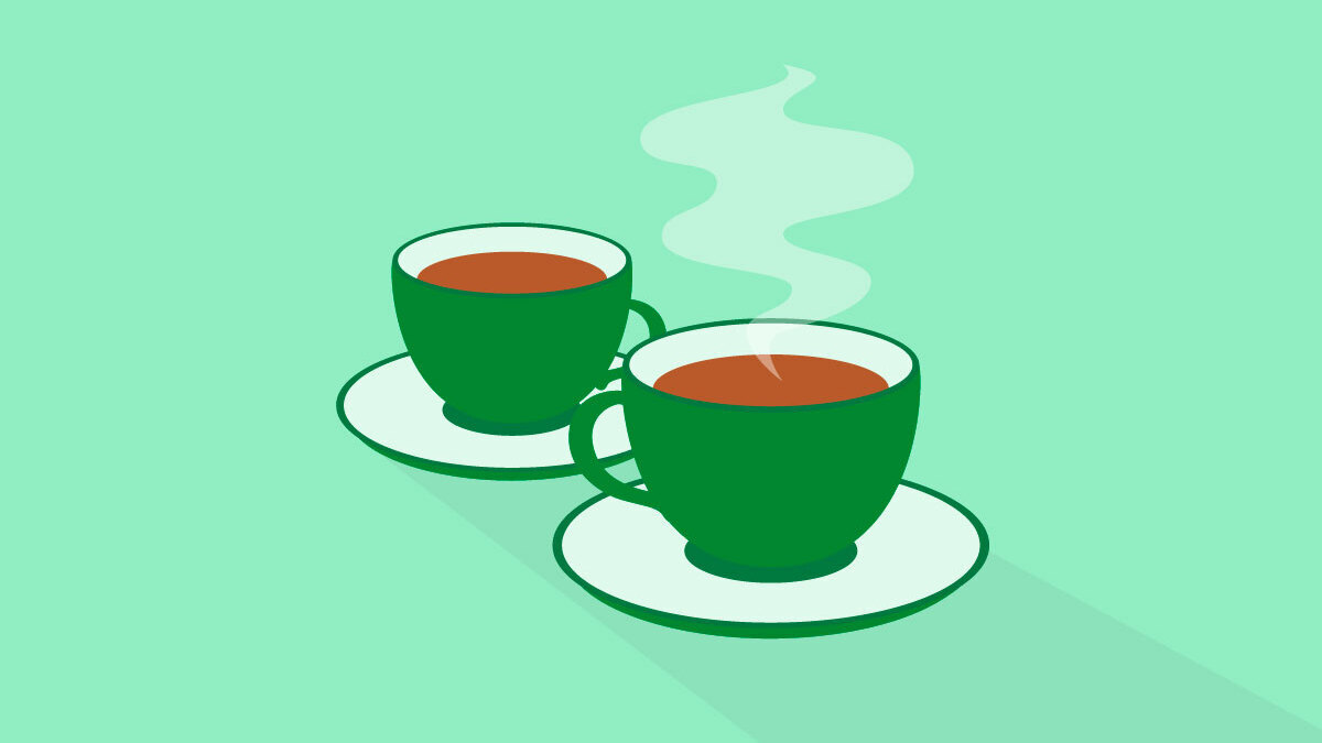 Two dark green teacups on a light green background.