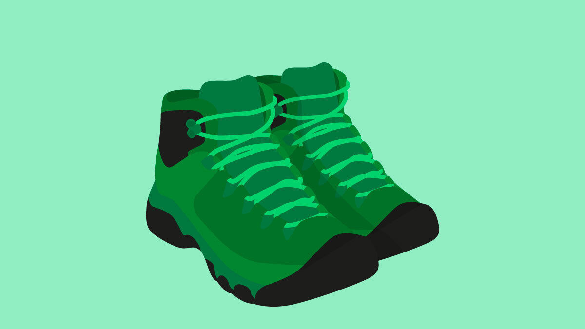 Dark green hiking boots on a light green background.