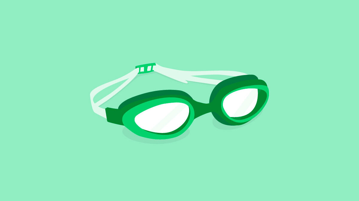 Dark green and white swimming goggles on a light green background.