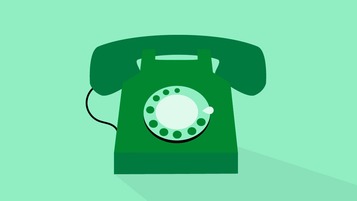 A dark green rotary phone on a light green background.