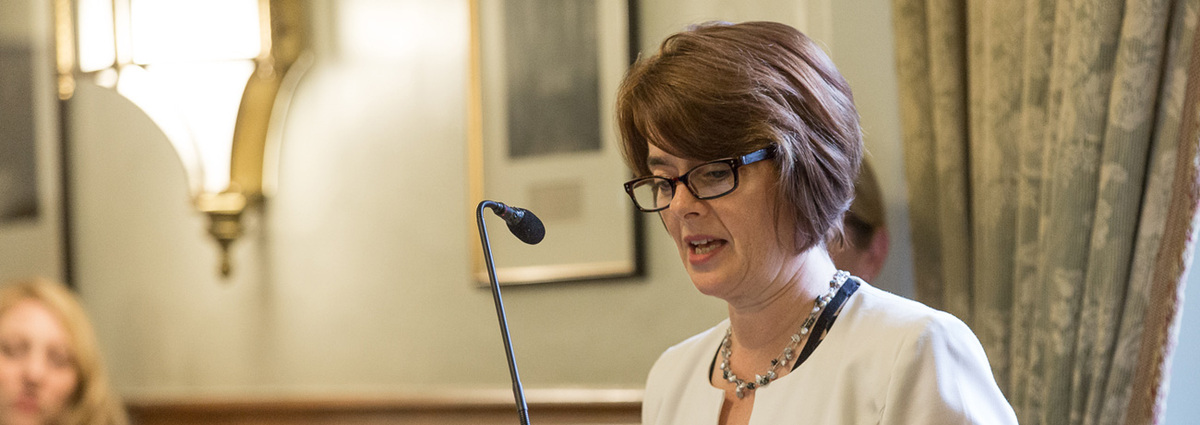 White lady speaking into a microphone at a APPGC meeting