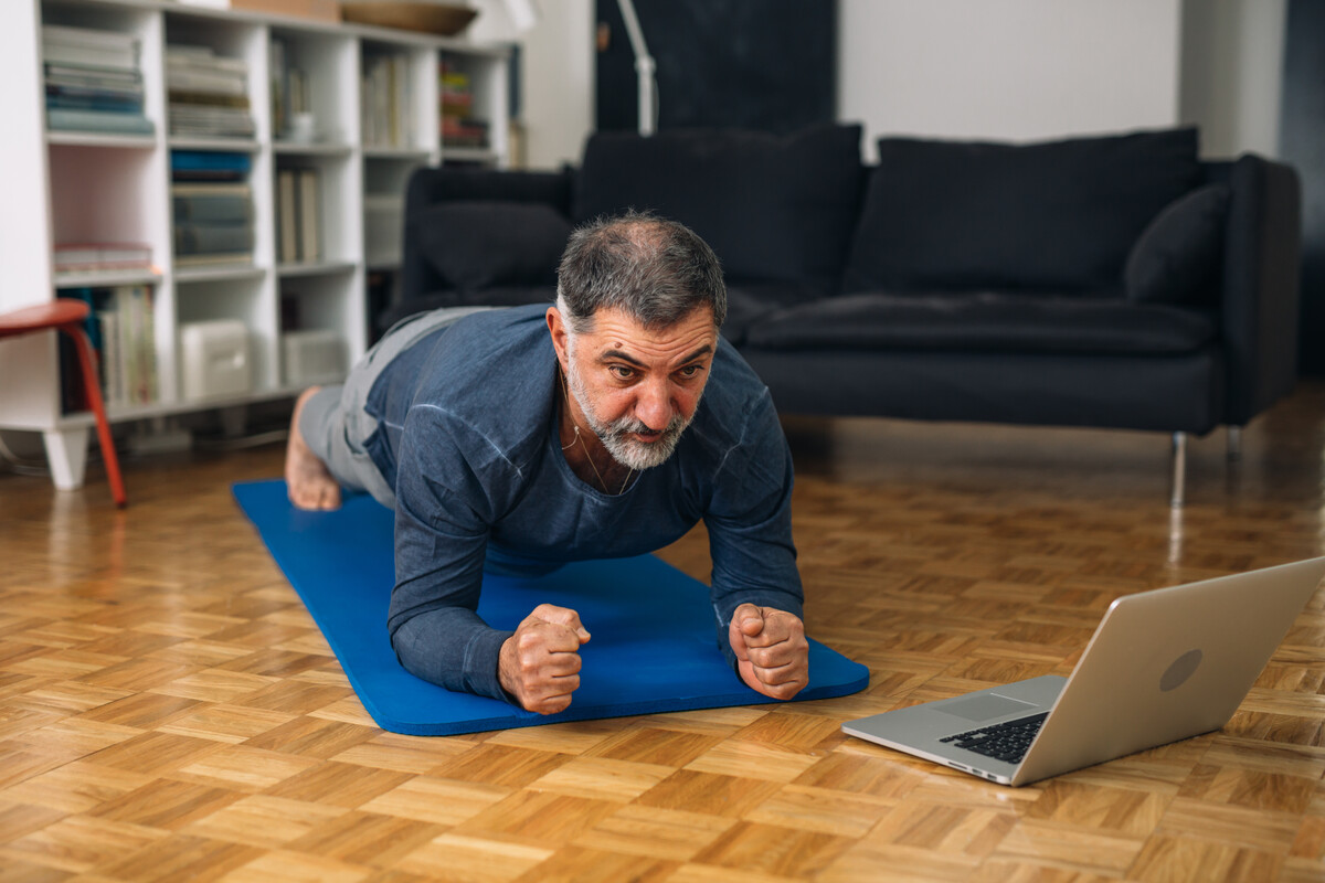 An Asian man doing a plank