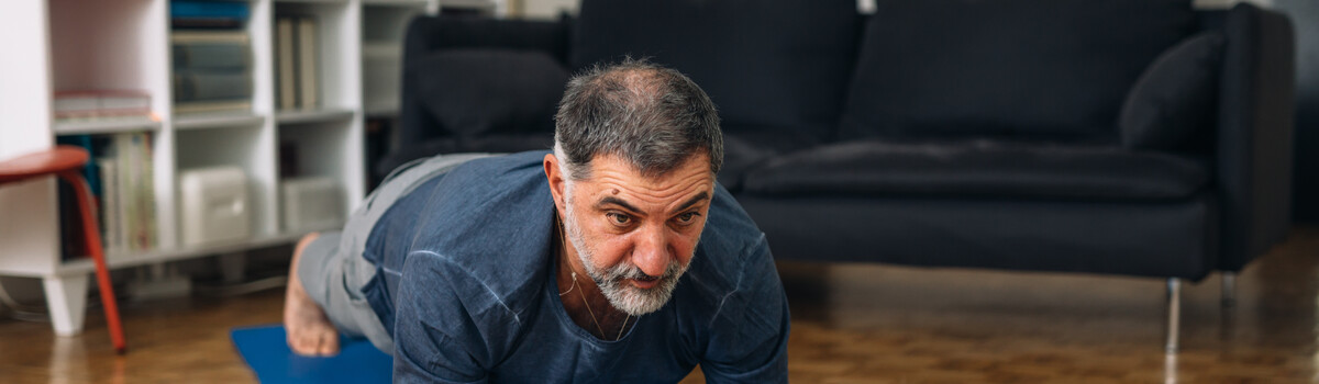 An Asian man doing a plank