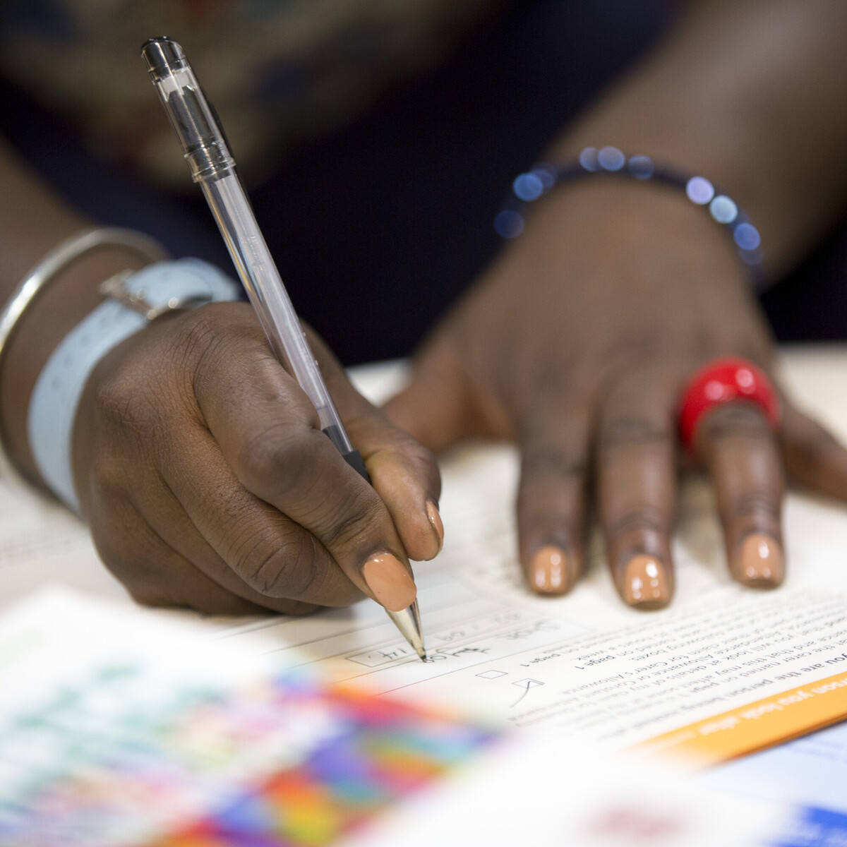 Close up of a woman's hands writing on an application form 