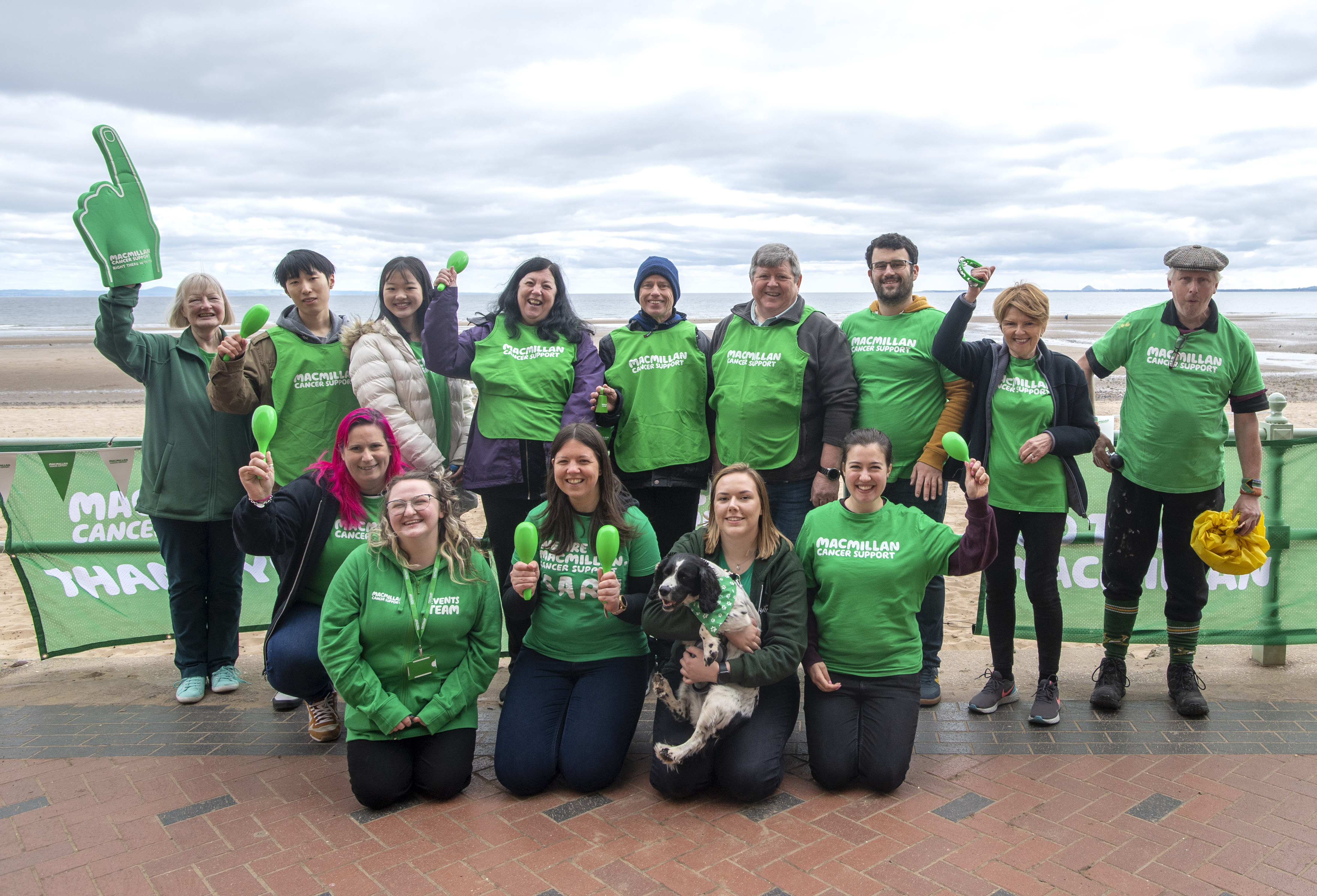 A group of Macmillan volunteers wearing T-shirts on the seafront