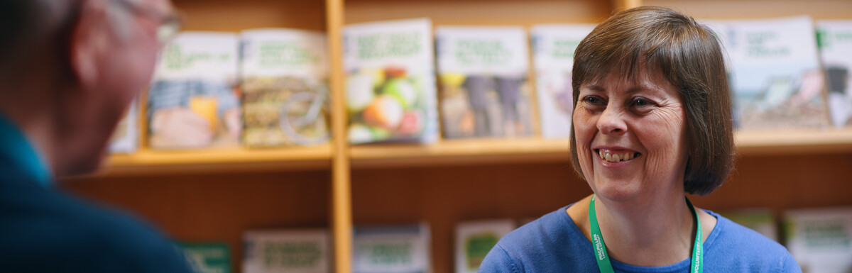 A lady with a blue jumper shares cancer information with a man.