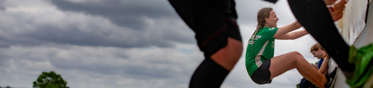 A woman scaling a ramp at a Tough Mudder event