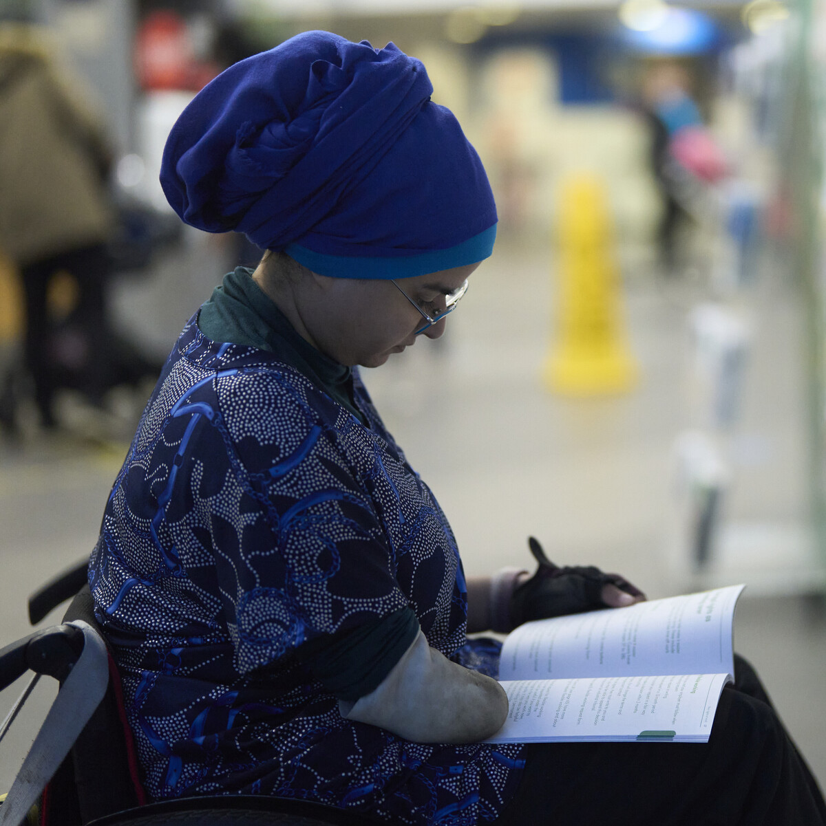 A woman in a wheelchair reading a booklet