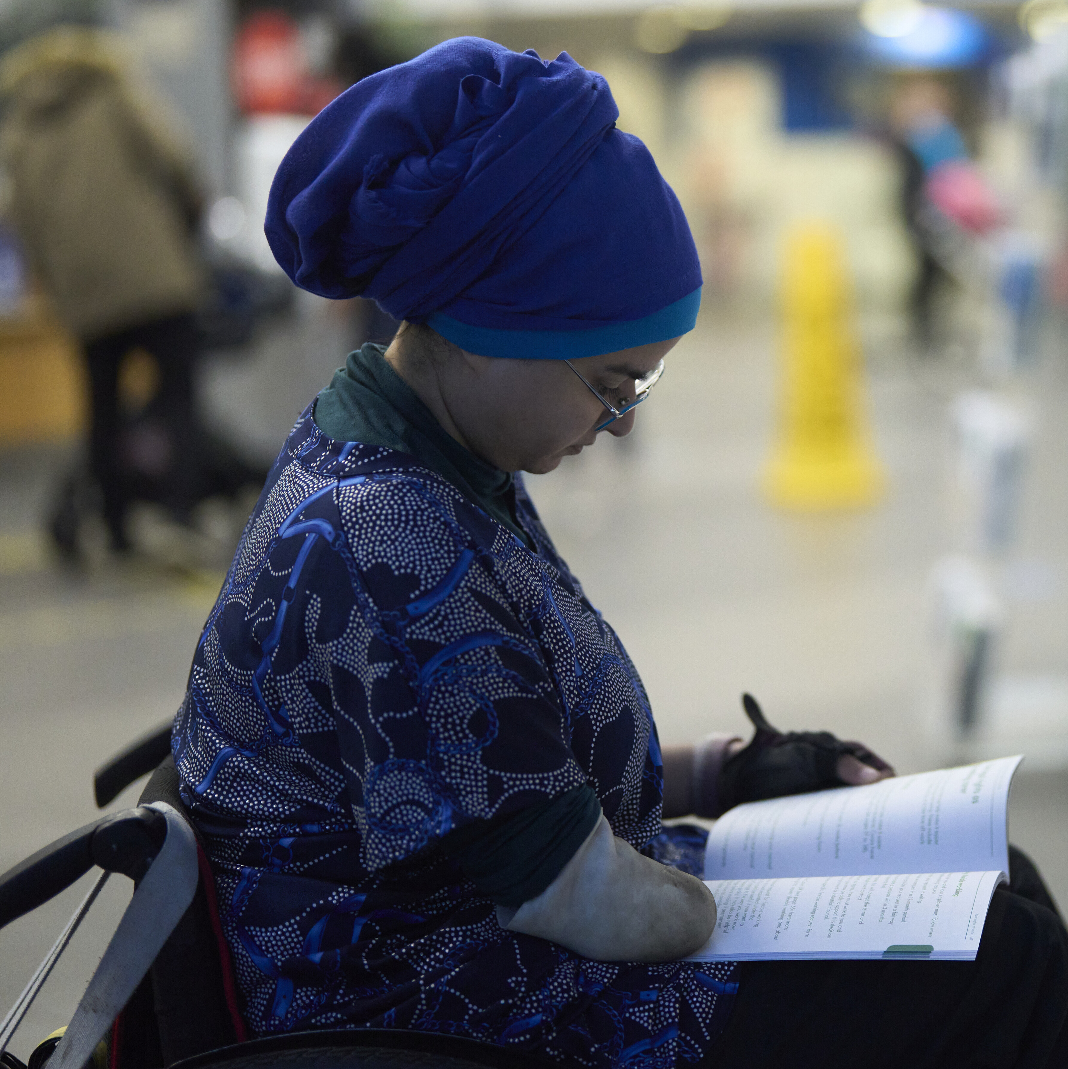A woman in a wheelchair reading a booklet