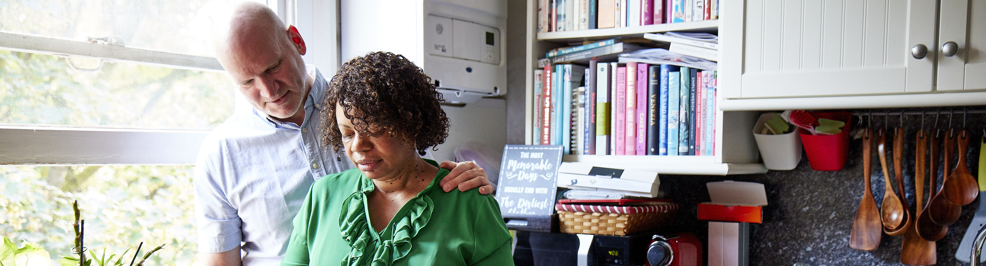 Debbie making a cup of tea in her kitchen with husband