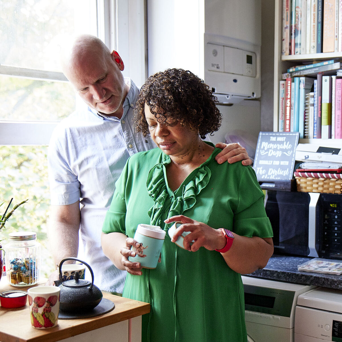 Debbie making a cup of tea in her kitchen with husband