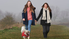 A couple walking their dog in the countryside