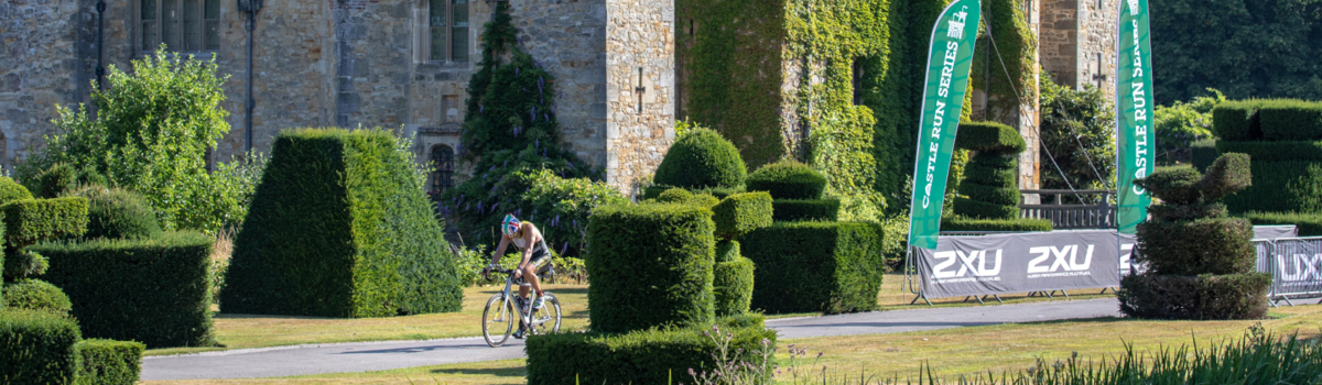 A cyclist riding past Hever Castle, Kent.