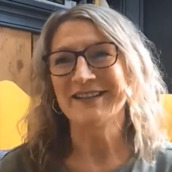 A lady wearing glasses talks about emotional support.